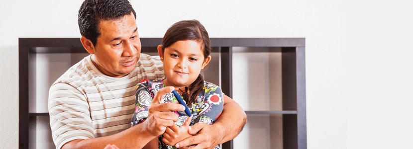 A father helping his daughter with a finger prick A1C test