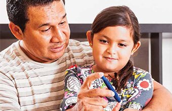 A father helping his daughter take an A1C test